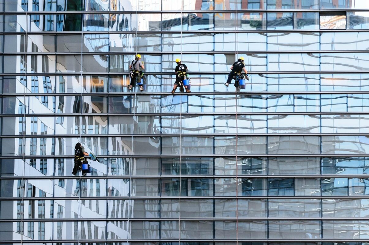 A squeegee drawing a clean line down a wet window